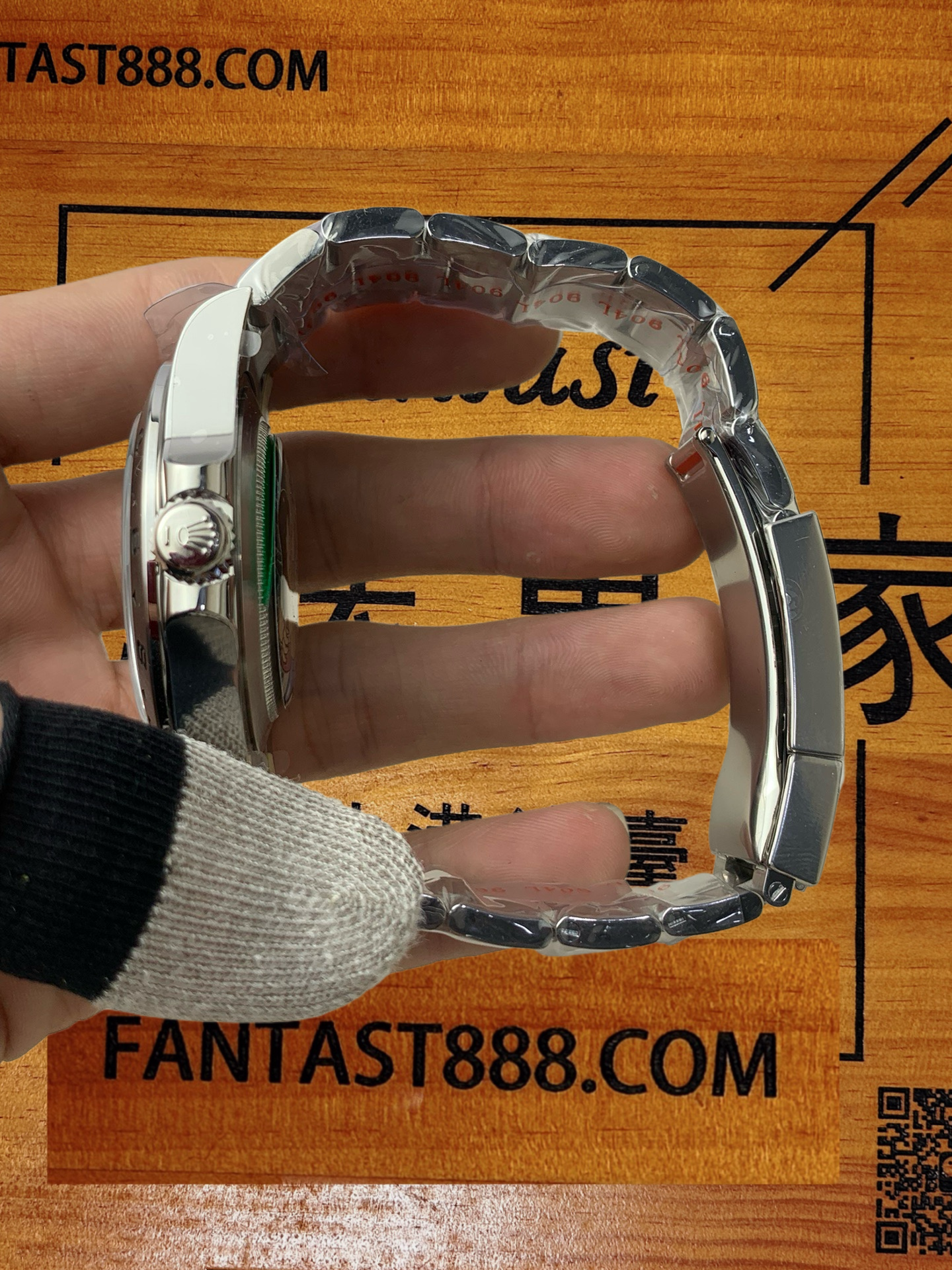 勞力士探險家型II腕錶正面展示，黑色錶盤清晰顯示白色時標、日期視窗及橙色GMT指針，不鏽鋼錶圈刻有24小時刻度，背景木板印有品牌標誌及「FANTAST888.COM」網址。
