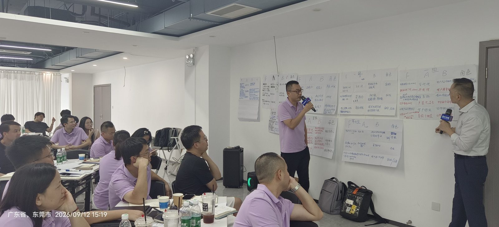 The instructor explaining group work pinned on the wall