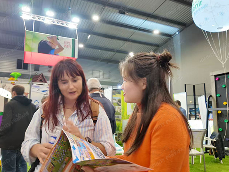 Business consultation and materials review at Infinity Funpark exhibition booth