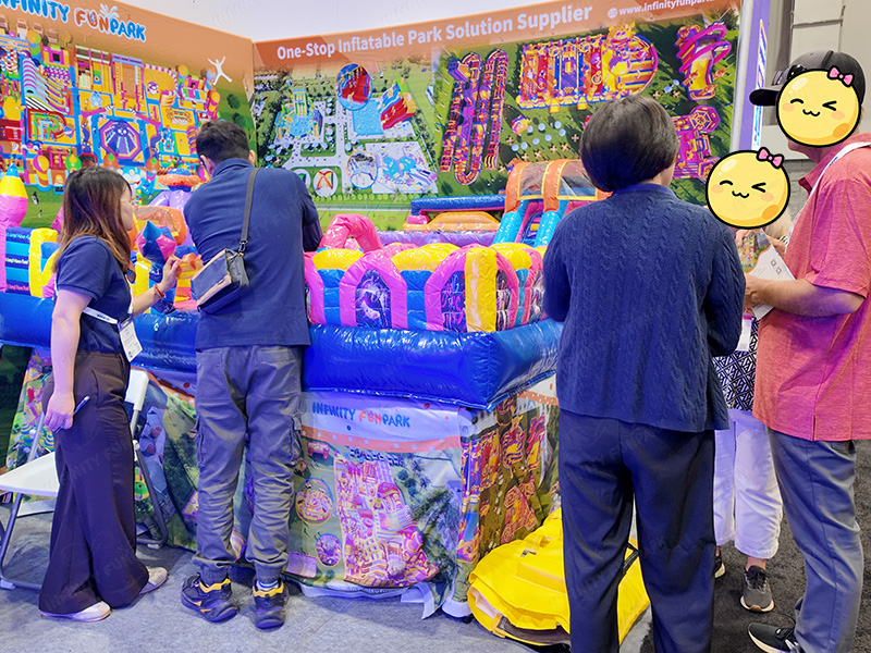 Busy Infinity Funpark booth at IAAPA Expo with multiple visitors