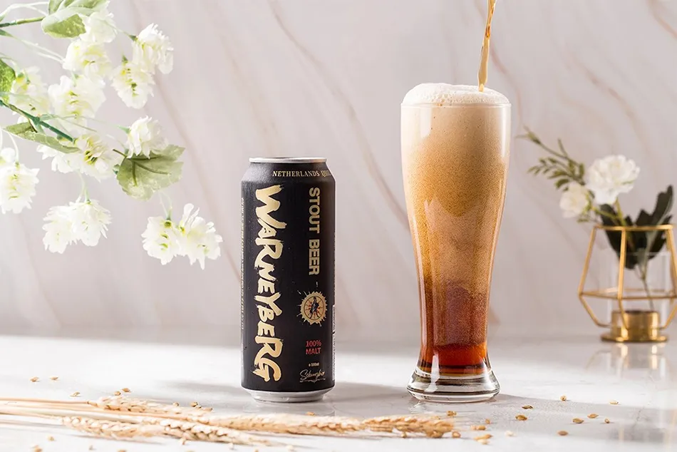 craft stout beer pouring into glass with creamy foam