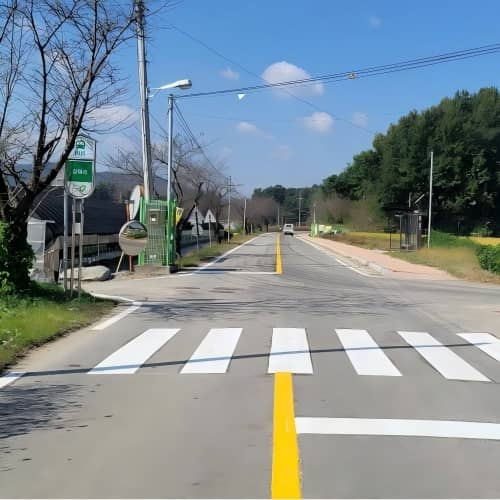 인천 시내 횡단보도에 시공된 열가소성 도로 표시 페인트, 배경에 한글 간판이 보임