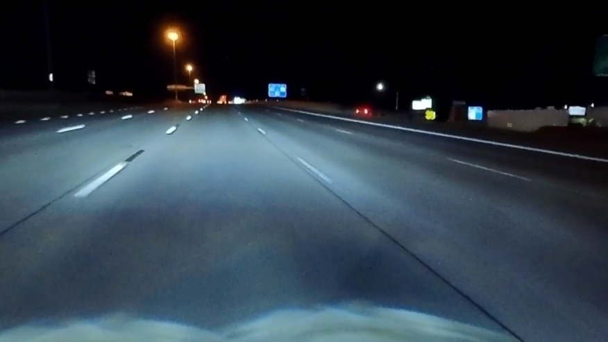 Reflective road markings enhance visibility on wet roads during a rainy night in Chile.