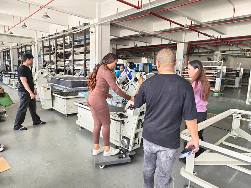 Cliente experimentando con la m&aacute;quina ribeteadora de colchones