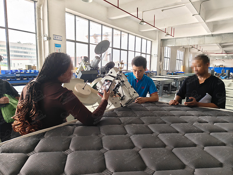 Cliente observando el funcionamiento de la m&aacute;quina ribeteadora de colchones