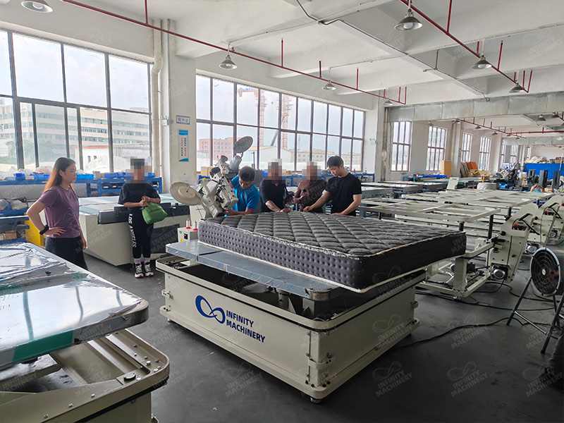 Vendedor explicando la m&aacute;quina ribeteadora de colchones