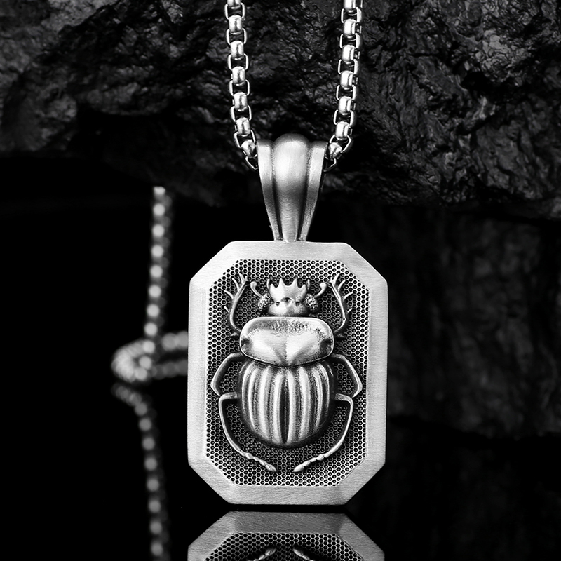 Solid lead-free pewter pendant featuring a 3D relief of an ancient Egyptian Scarab beetle set inside a rectangular frame with a textured background