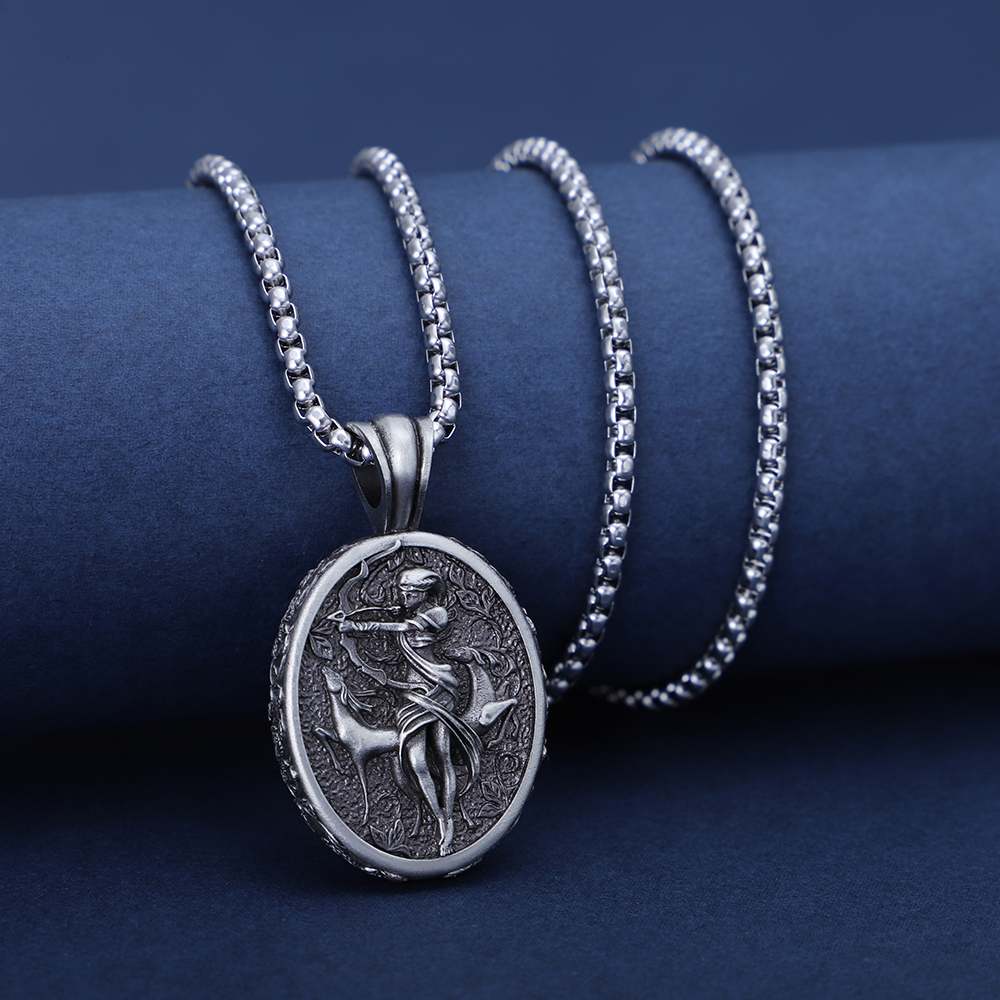 Solid lead-free pewter oval pendant featuring a detailed 3D relief of the Greek Goddess Artemis drawing a bow, accompanied by a sacred stag in a wild forest setting