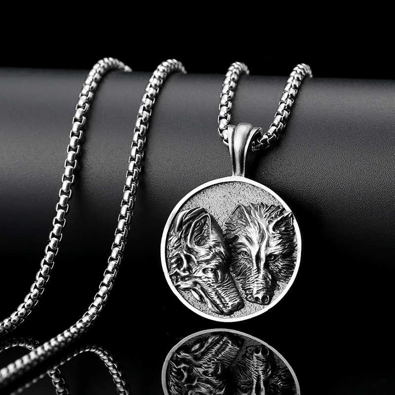 Solid lead-free pewter round medallion pendant featuring a highly detailed 3D relief of two wolves side-by-side against a textured stippled background