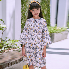 New girls' geometric printed dress: a white base with colorful patterns resembling bows, paired with lively flared sleeves, fully embodying the fashionable and childlike style.