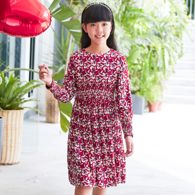 Current children's dress has a red base with floral patterns, a waist - cinching design, long sleeves, retro prints, and is artistic, literary and cute.