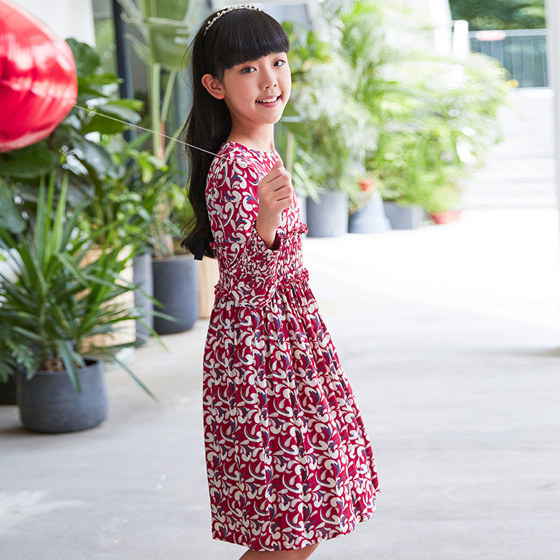 Current children's dress has a red base with floral patterns, a waist - cinching design, long sleeves, retro prints, and is artistic, literary and cute.