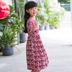 Current children's dress has a red base with floral patterns, a waist - cinching design, long sleeves, retro prints, and is artistic, literary and cute.