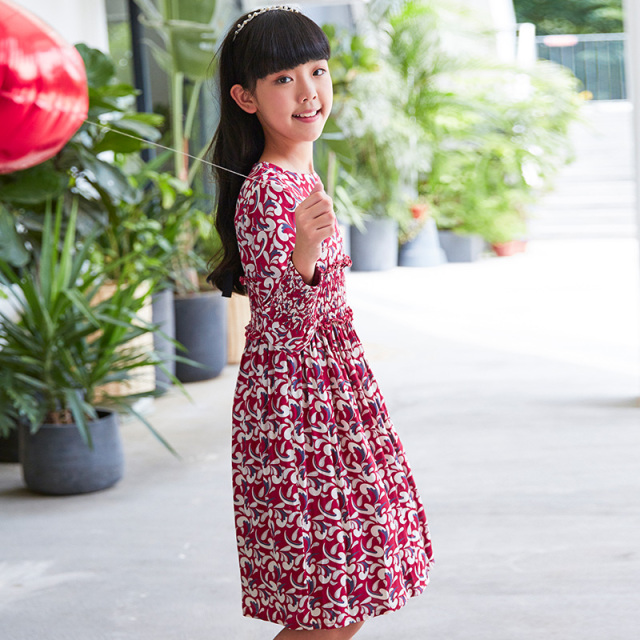 Current children's dress has a red base with floral patterns, a waist - cinching design, long sleeves, retro prints, and is artistic, literary and cute.