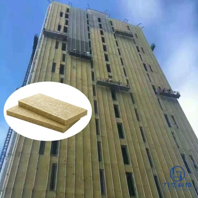 high-rise building construction site with workers installing Class A1 fireproof rock wool insulation for ETICS with high tensile strength TR15 in suspended platforms