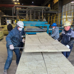 Factory workers carrying large rock wool blanket sheets on the production line at Anhui Liluan Technology factory