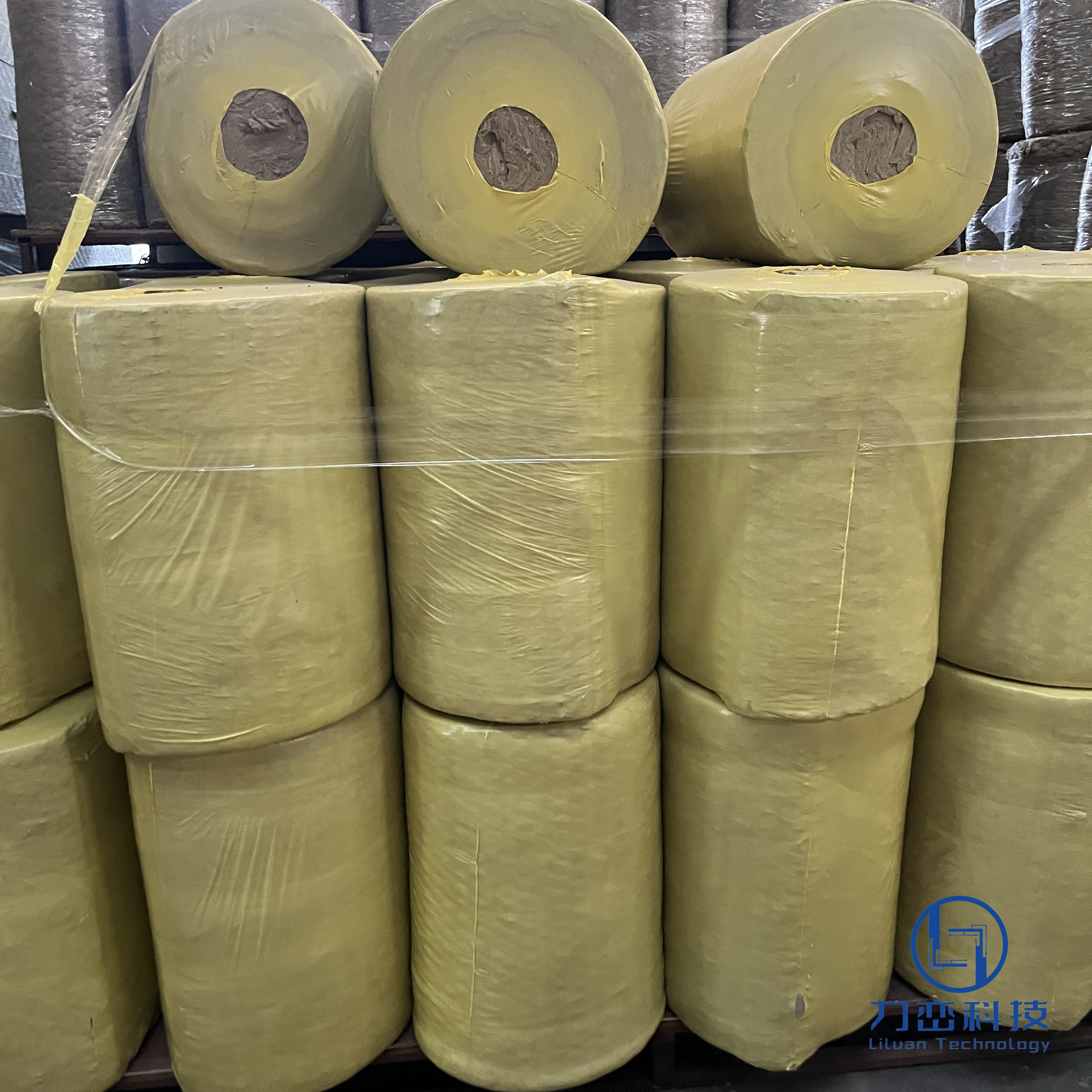 Large quantities of rock wool roll blanket with wire mesh neatly stacked in warehouse ready for industrial insulation projects - Liluan Technology