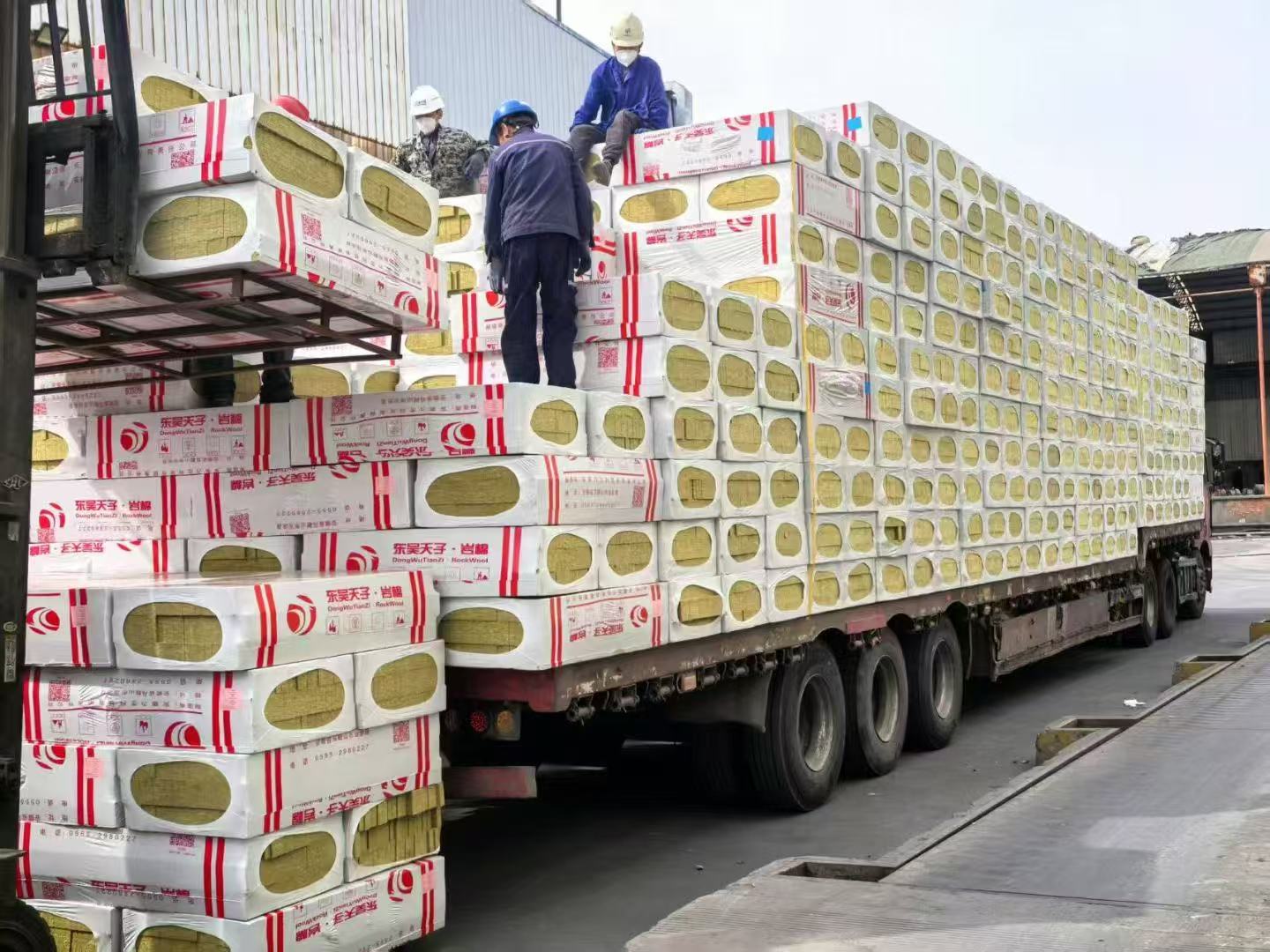 Workers loading rock wool strip lamella boxes onto truck for exterior wall fire protection projects – professional fire-rated insulation by Liluan Technology