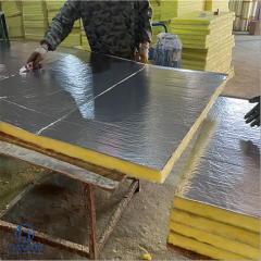 Worker applying aluminum foil facing to glass wool board – manufacturing lightweight thermal & acoustic insulation by Liluan Technology