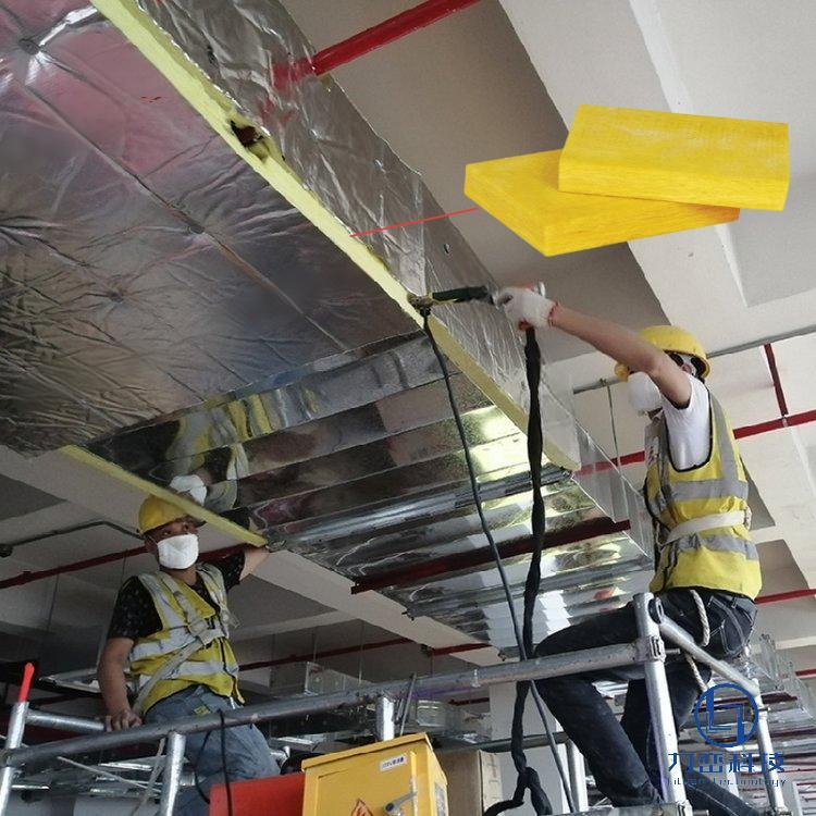 Workers installing glass wool board with aluminum foil on ceiling duct – lightweight thermal and acoustic insulation application by Liluan Technology