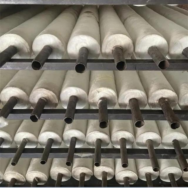Long aluminum silicate pipes neatly stacked on metal racks in warehouse production line– industrial high-temperature pipe insulation by Liluan Technology