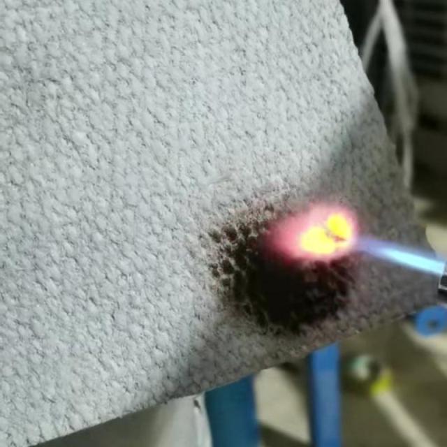 Ceramic fiber textile undergoing flame resistance test with blowtorch – demonstrating extreme high-temperature insulation performance by Liluan Technology