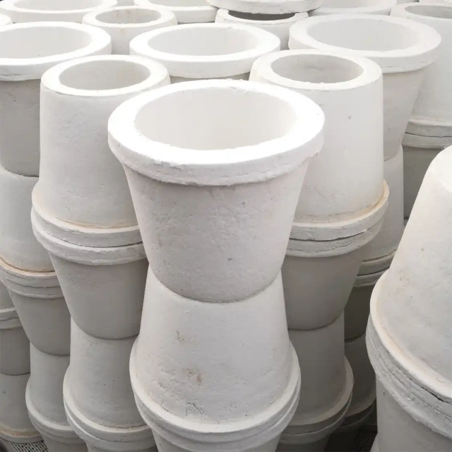 Stacks of identical conical ceramic fiber special-shaped parts, likely used as crucibles or flow distributors, neatly stacked together in a warehouse for bulk supply——LiLuan Technology