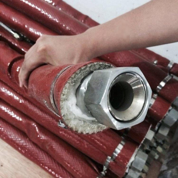Industrial application of Liluan red fire sleeve protecting a bundle of hydraulic hoses and metal fittings in high-heat metallurgy environments.---LiLuan Technology