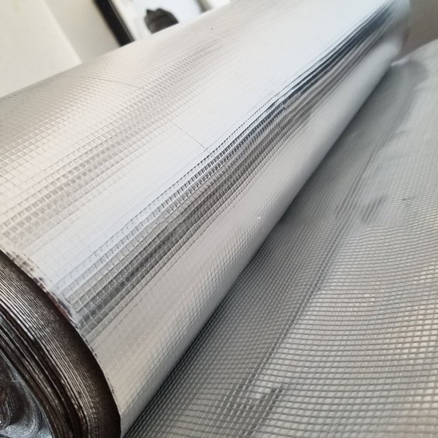Extreme close-up of the fine grid pattern on the aluminum surface of a roll of AFGFC, showing the precise Fiber weave and a metallic straight edge for precision demonstration.---LiLuan Technology