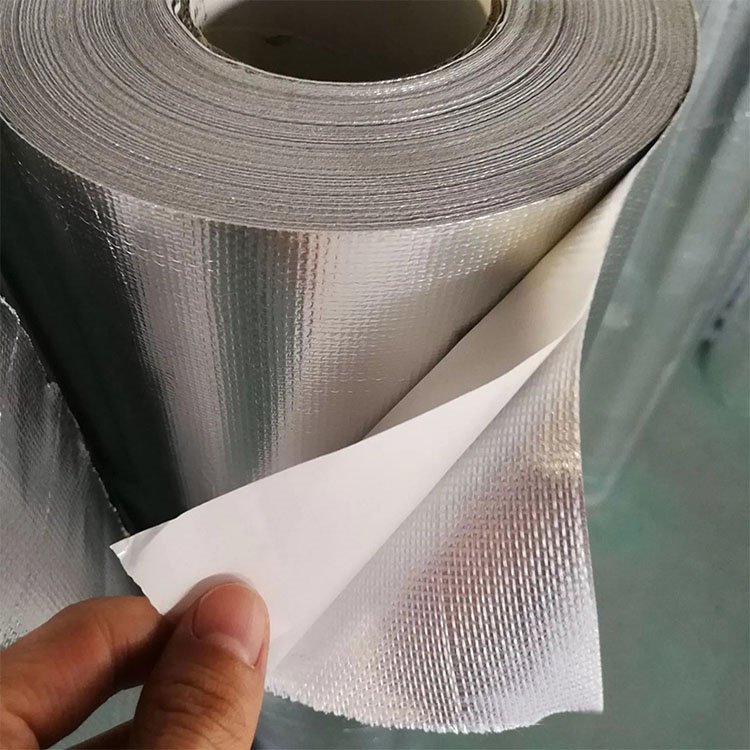 A hand peeling back the white paper release liner to demonstrate the self-adhesive backing of Liluan aluminum foil glass Fiber cloth, emphasizing its ease of installation.---LiLuan Technology