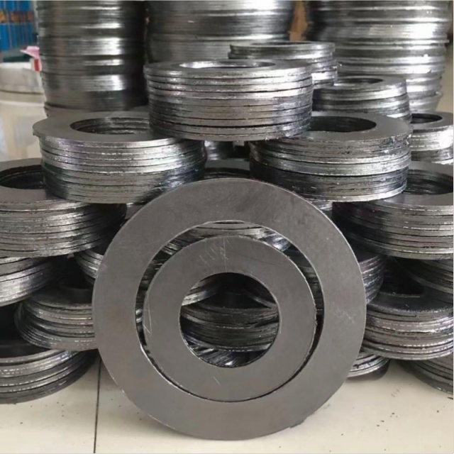A warehouse photograph showing dense stacks of thick, heavy-duty Liluan high-strength graphite flange gaskets. A single large-diameter gasket is stood upright in the foreground, displaying its smooth face and significant thickness, emphasizing its increased load-bearing capacity and robust construction required for extreme industrial stresses.---LiLuan Technology