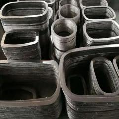 A detailed top-down view of multi-layered stacks of Liluan high-strength composite graphite gaskets. The gaskets are in various nested oval and rectangular shapes on an industrial work surface, ready for installation. The close-up view of the edges reveals the complex alternating layers of graphite and multiple metal reinforcement inserts, illustrating the high-strength multi-layer construction required for non-circular applications like high-pressure valve bonnets.---LiLuan Technology