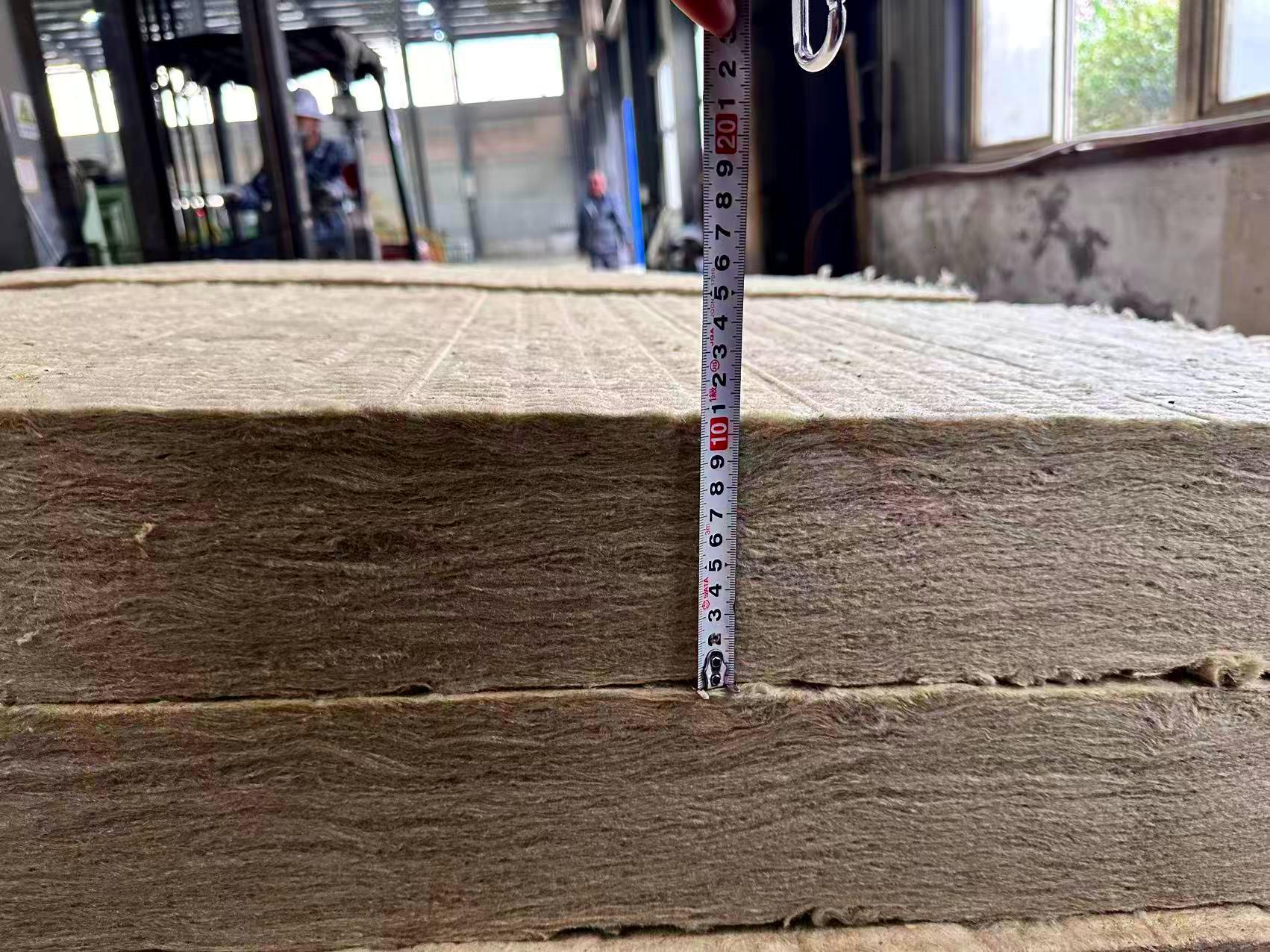 Close-up of high-density rock wool roll (mineral wool insulation blanket) being measured for thickness in our factory, fireproof thermal insulation rock wool for building walls, roofs, and industrial high-temperature insulation applications-LiLuan Technology
