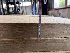 Close-up of high-density rock wool roll (mineral wool insulation blanket) being measured for thickness in our factory, fireproof thermal insulation rock wool for building walls, roofs, and industrial high-temperature insulation applications-LiLuan Technology