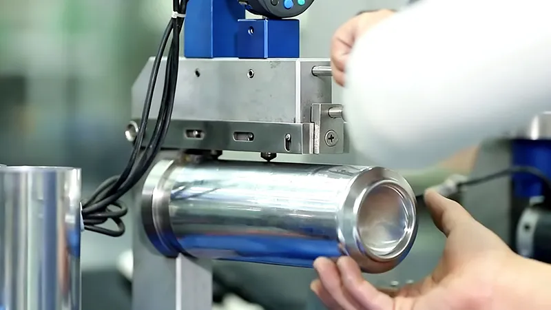 Quality inspector using digital micrometer to measure aluminum beverage can wall thickness in factory production line.