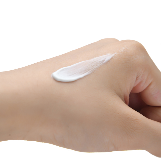 A close-up of the moisturizing, non-greasy cream texture of our private label Vitamin C sunscreen, demonstrating a comfortable feel ideal for daily use in mass-market lines.