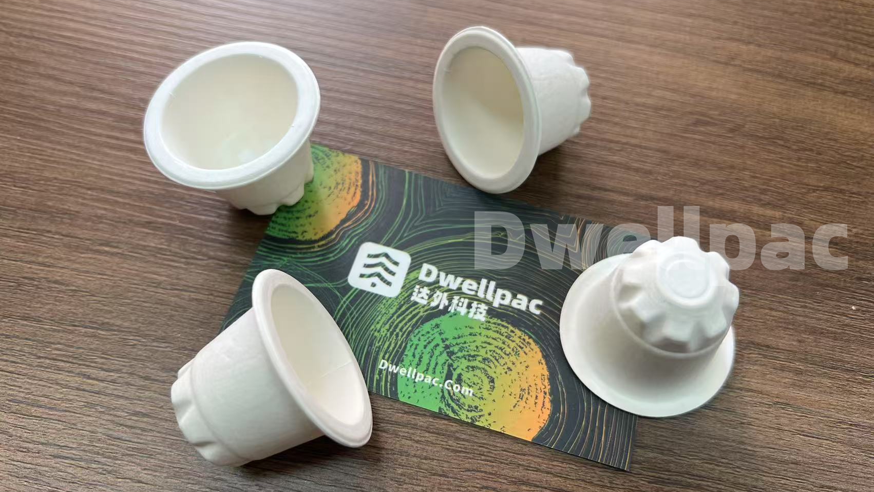 White molded pulp cup samples with shaped outer surfaces displayed on a table