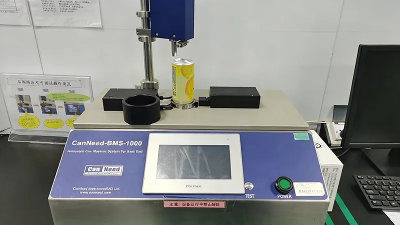 A quality control technician inspecting aluminum cans for integrity and label accuracy. This visual underscores the rigorous safety standards (ISO/FSSC) essential for global beverage compliance.