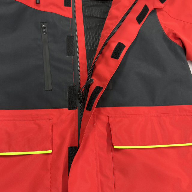 Rote Segeljacke mit hohem Kragen, neongrünen Ellbogen und Kapuze