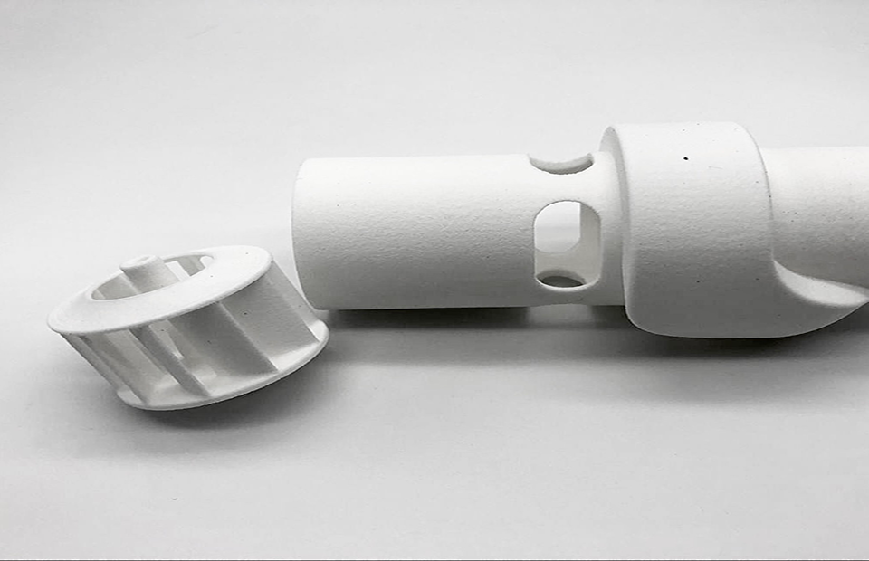 White SLS printed part used for material routing
