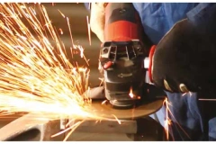 A close-up action shot of a FUJI JITAN Grinding Wheel smoothly grinding a steel workpiece