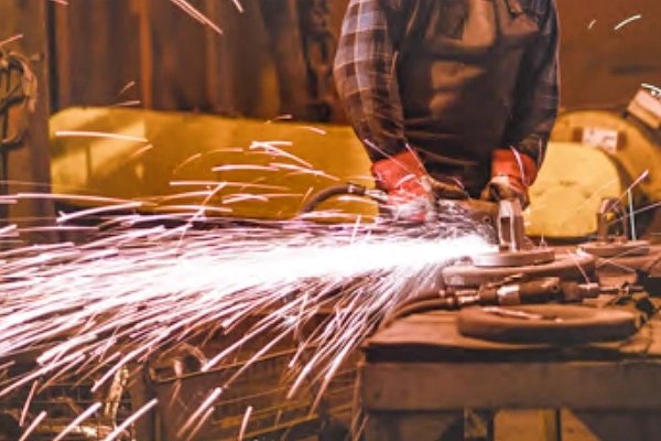 FUJI High-Frequency Grinder with specialized wheel removing casting imperfections in a foundry environment with sparks 