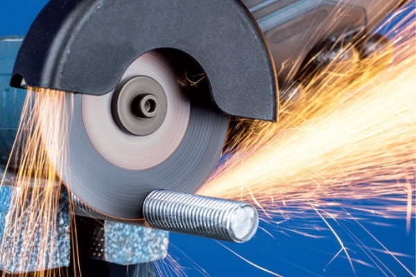 FUJI KIREMONO 4-inch cutting disc in action on an angle grinder, demonstrating a clean, fast cut on a steel bar.