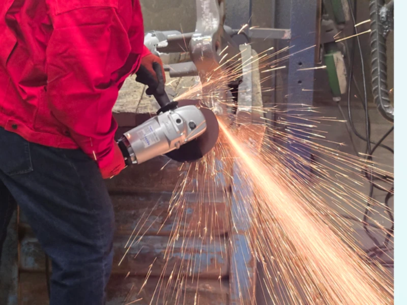 Un travailleur de fonderie utilisant une meuleuse droite &agrave; haute fr&eacute;quence FUJI associ&eacute;e &agrave; une meule FUJI