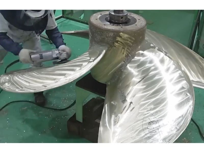 Pekerja galangan kapal menggunakan gerinda frekuensi tinggi FUJI HGC-3902 untuk memoles bilah baling-baling kapal perunggu nikel-aluminium yang besar
