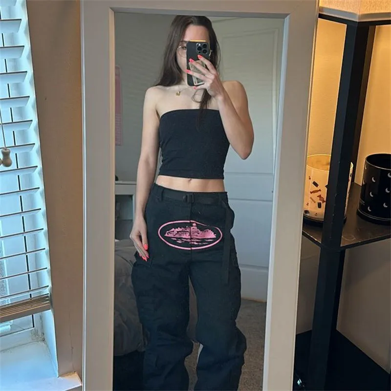 Black and pink Corteiz cargos worn with a simple daytime upper-body look