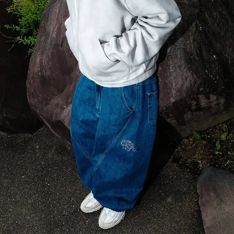 Blue Mertra Bigstep Denim Jeans worn with a pale hoodie, showing the visible hoodie hem and wide leg volume
