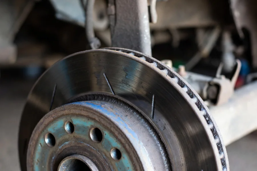 Worn brake disc with visible damage such as grooves and cracks, highlighting signs of wear and tear