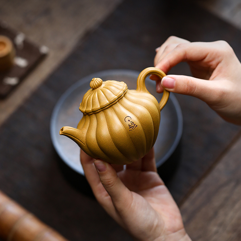 Dong Yuefeng, a famous teapot maker in Yixing Zisha Raw Ore Gold Section with Lotus Seed in Clay Tendon Pattern, made the teapot by hand.