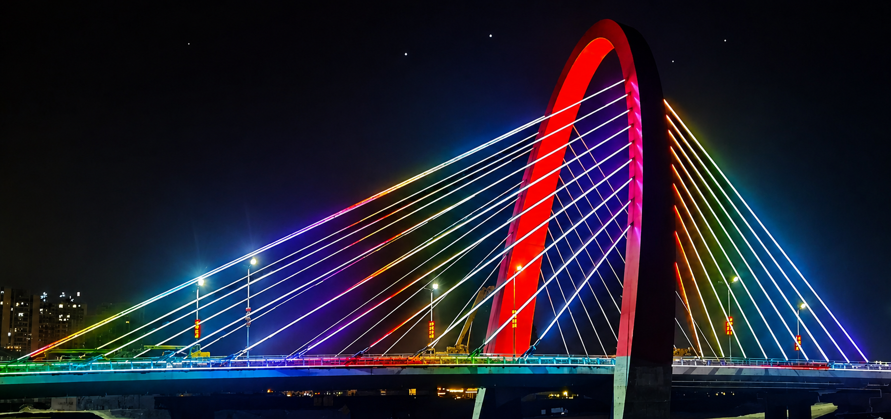 Night view of landmark arch cable-stayed bridge with cloud-based colorful RGB illumination